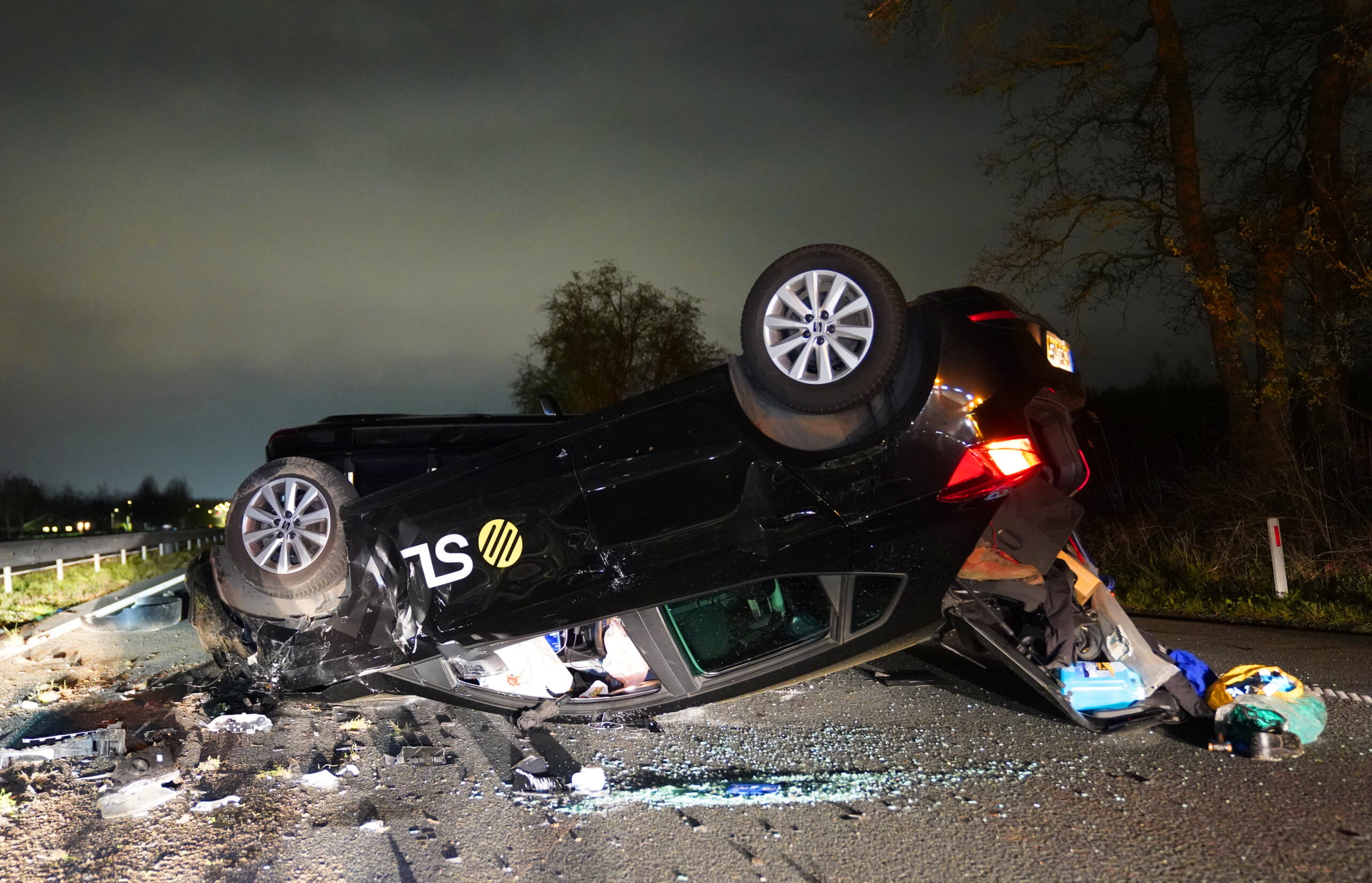 Auto over de kop na aanrijding, twee gewonden