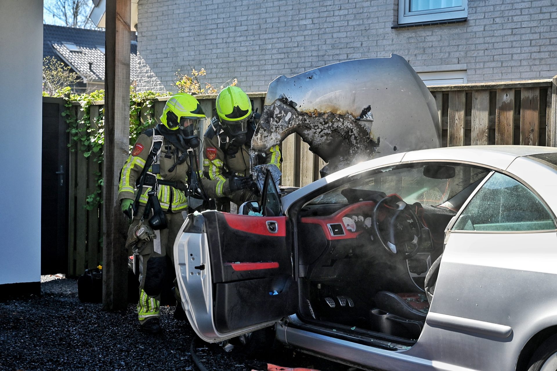 Auto vliegt in brand op oprit, buurtbewoners blussen vuur
