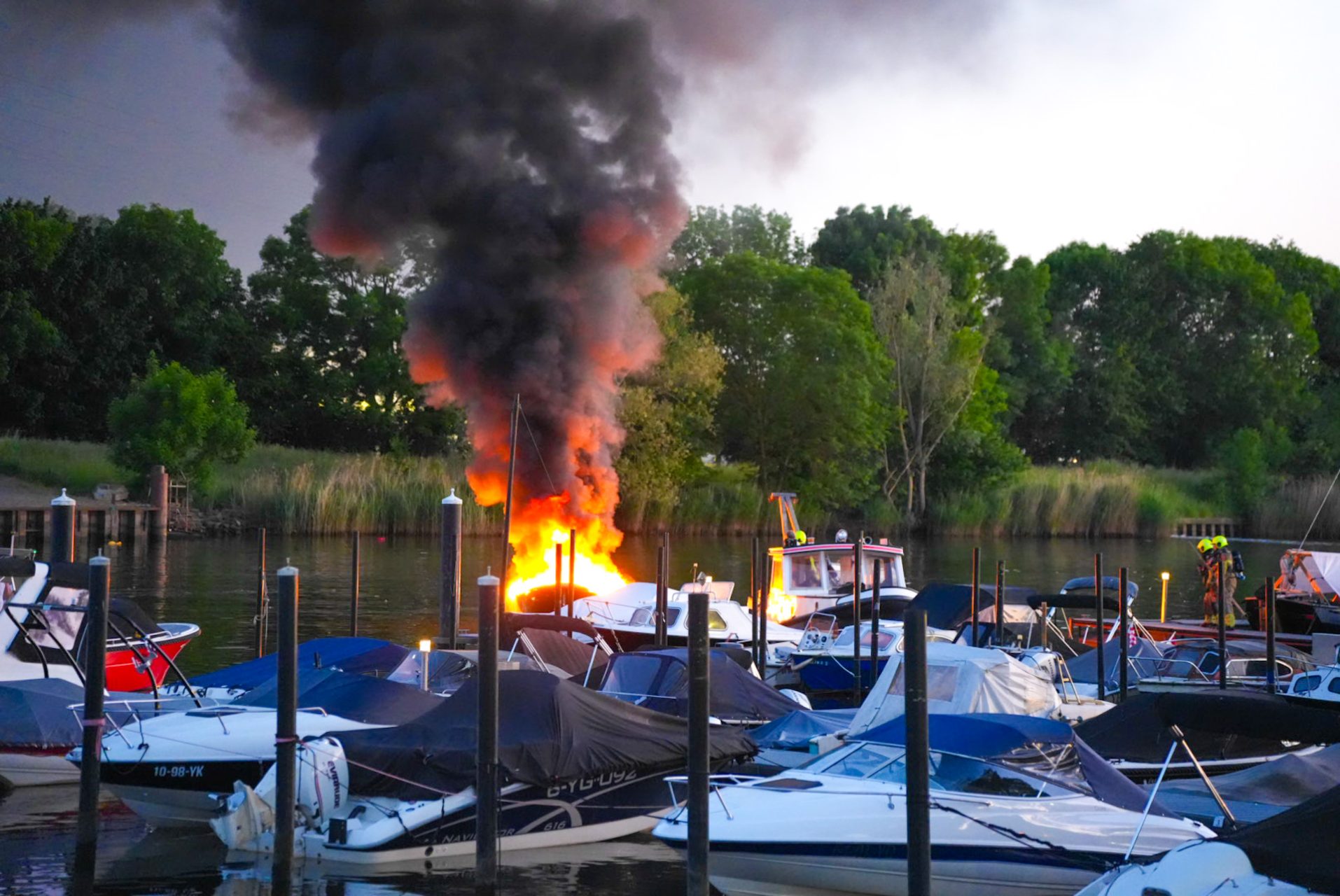 Sloep in lichterlaaie in jachthaven, opvarende gewond