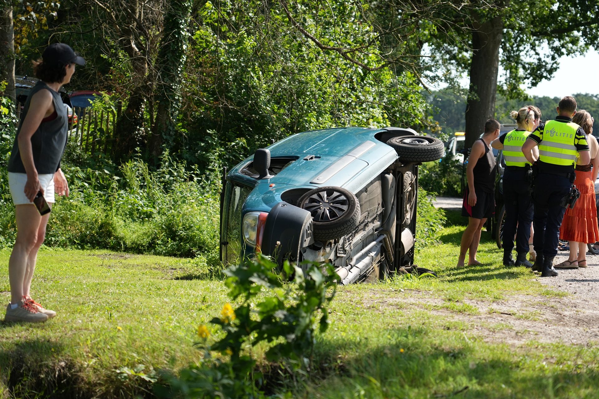 Auto met twee vrouwelijke inzittenden op zijkant in greppel Oosterhout