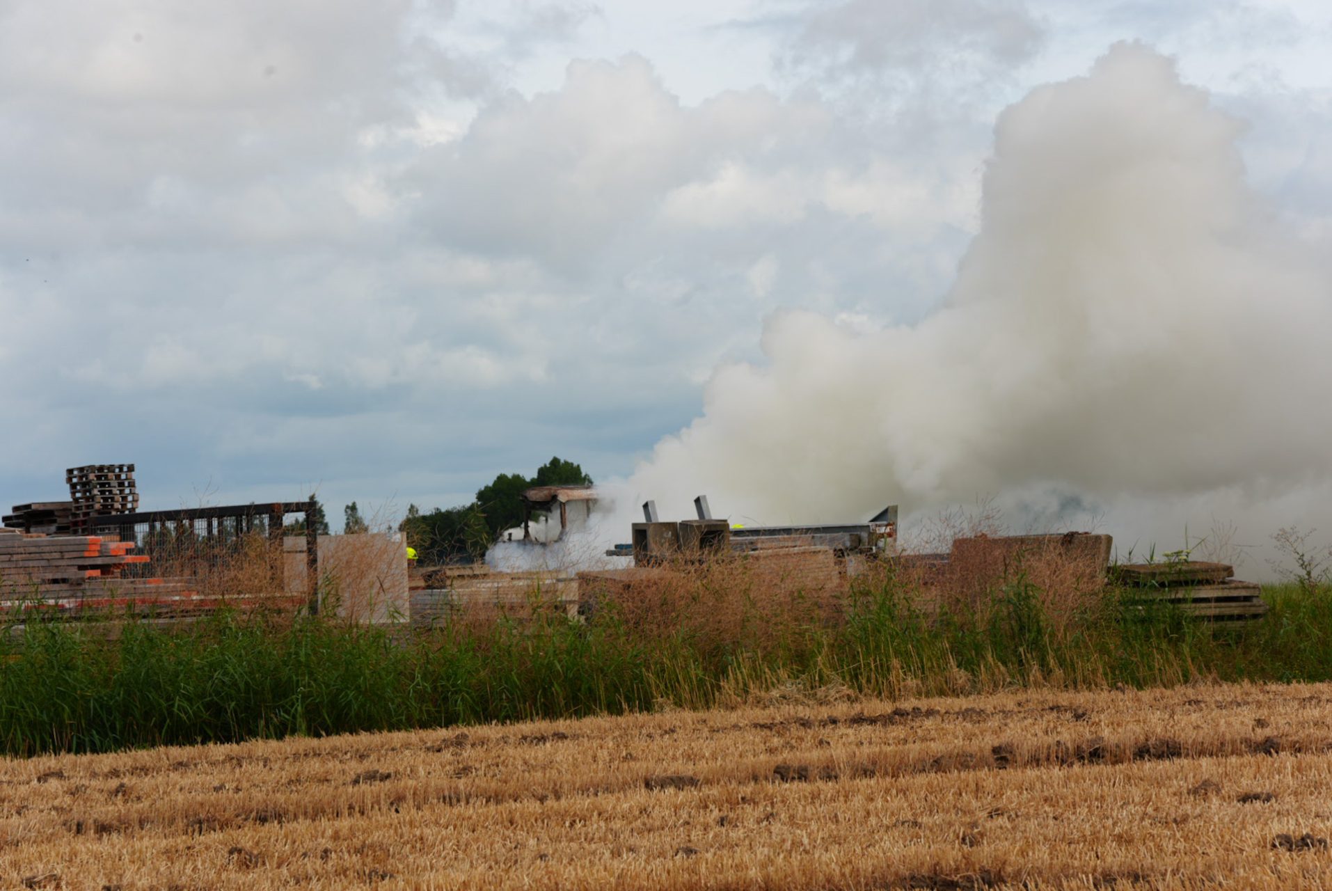 Tractor zwaar beschadigd door brand op erf bij bedrijf