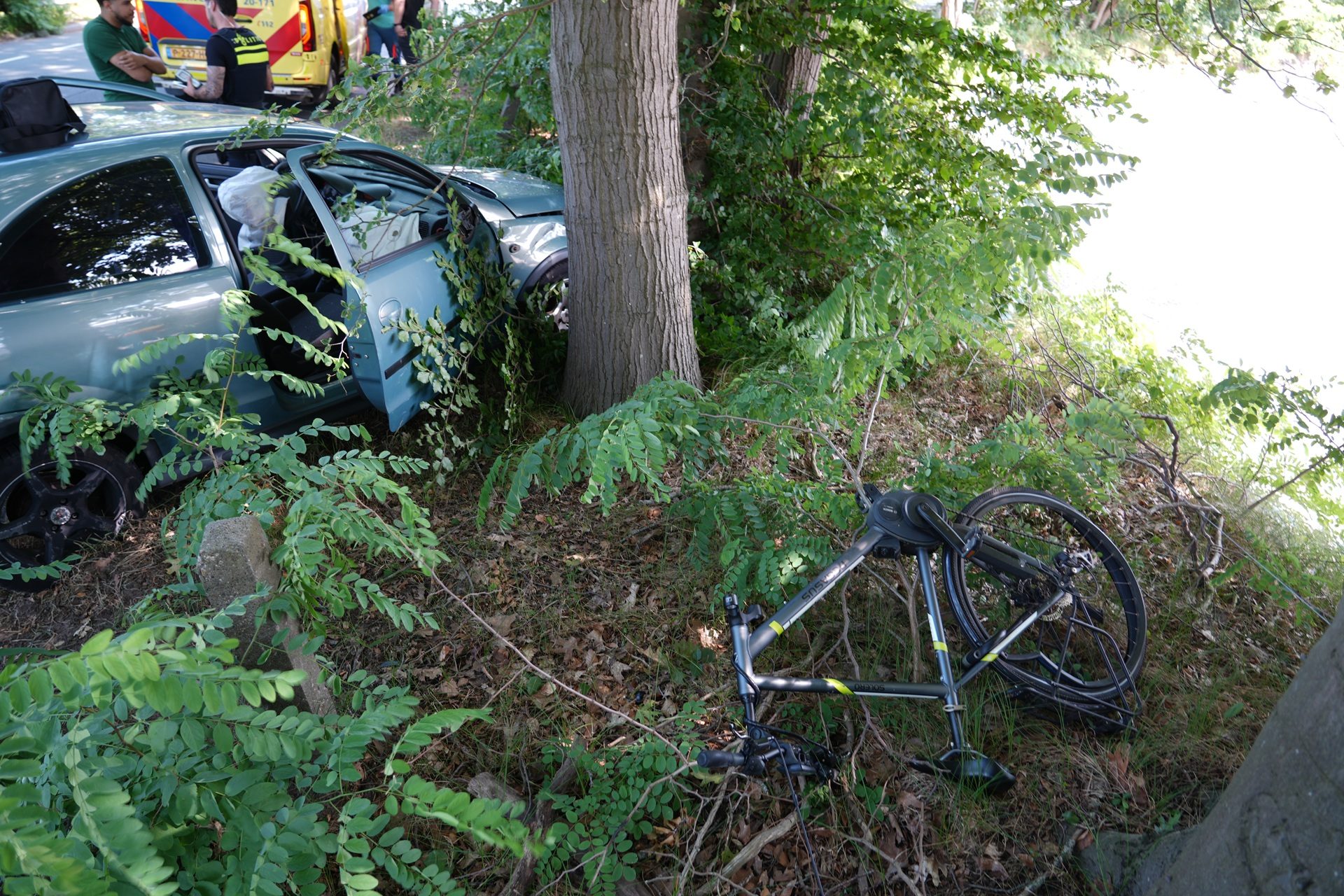 Auto schept fietser en botst tegen boom, fietser gewond