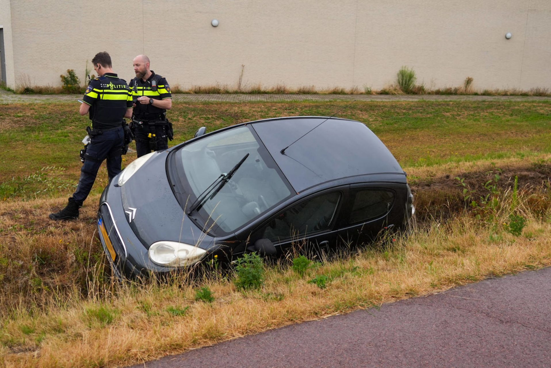 Auto belandt naast de weg in greppel
