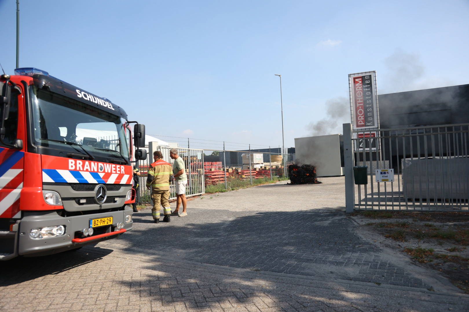 Brandend kopieerapparaat met heftruck naar buiten gebracht