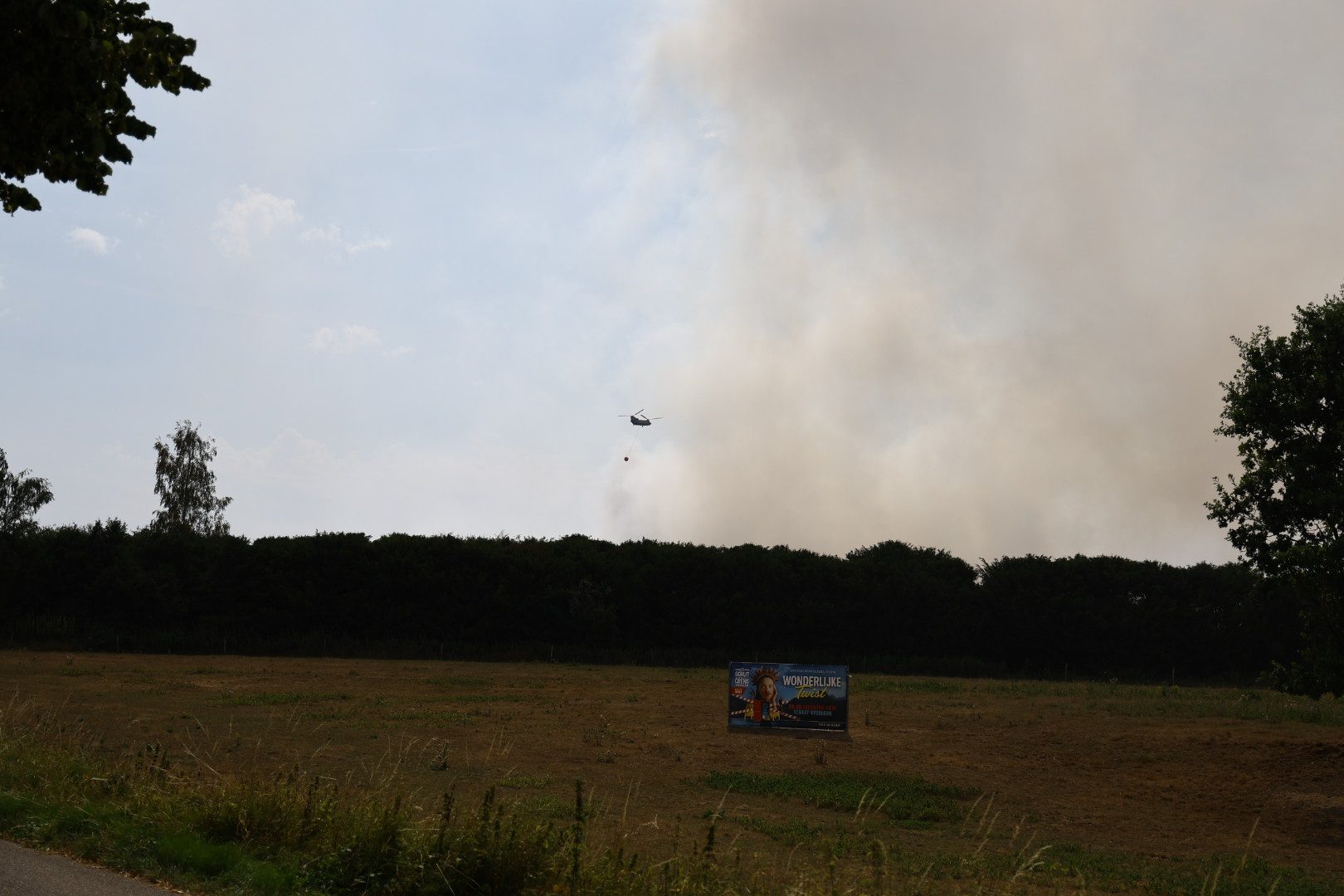 Chinooks vliegen af en aan boven natuurbrand in Oostrum