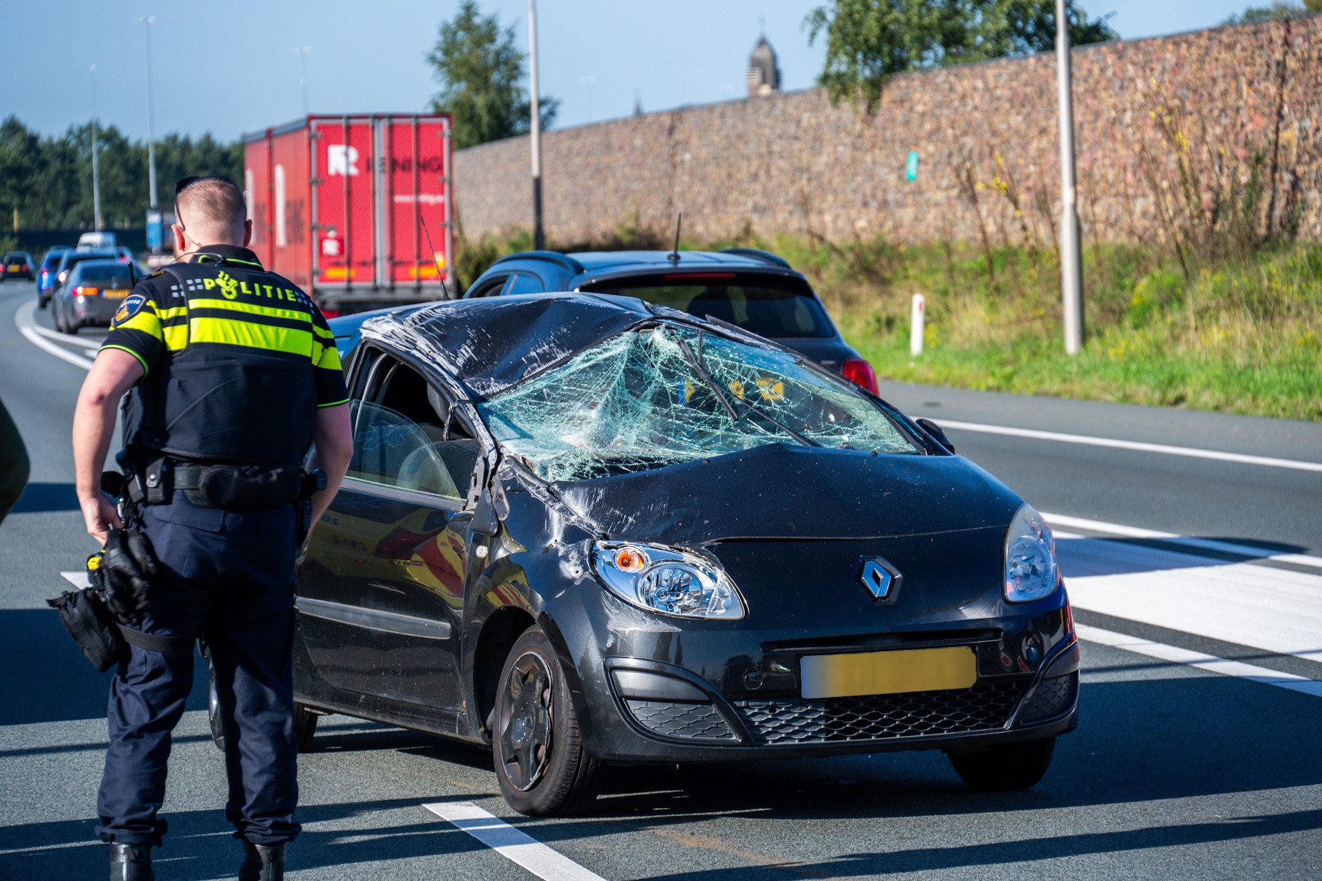 Auto over de kop na botsing met vrachtwagen