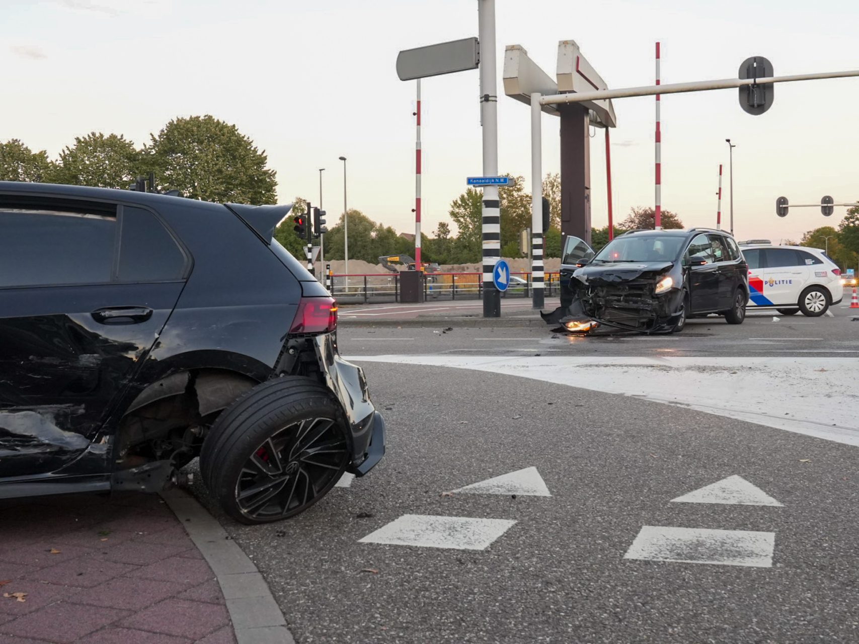 Twee auto’s botsen op kruising, brokstukken op de weg